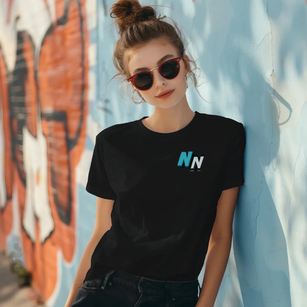 Woman in black NN logo t-shirt and sunglasses posing by colorful graffiti wall