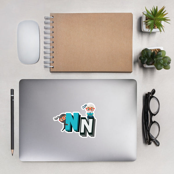 Laptop with cute NN kiss cut sticker on desk, surrounded by notebook, mouse, glasses, and succulents